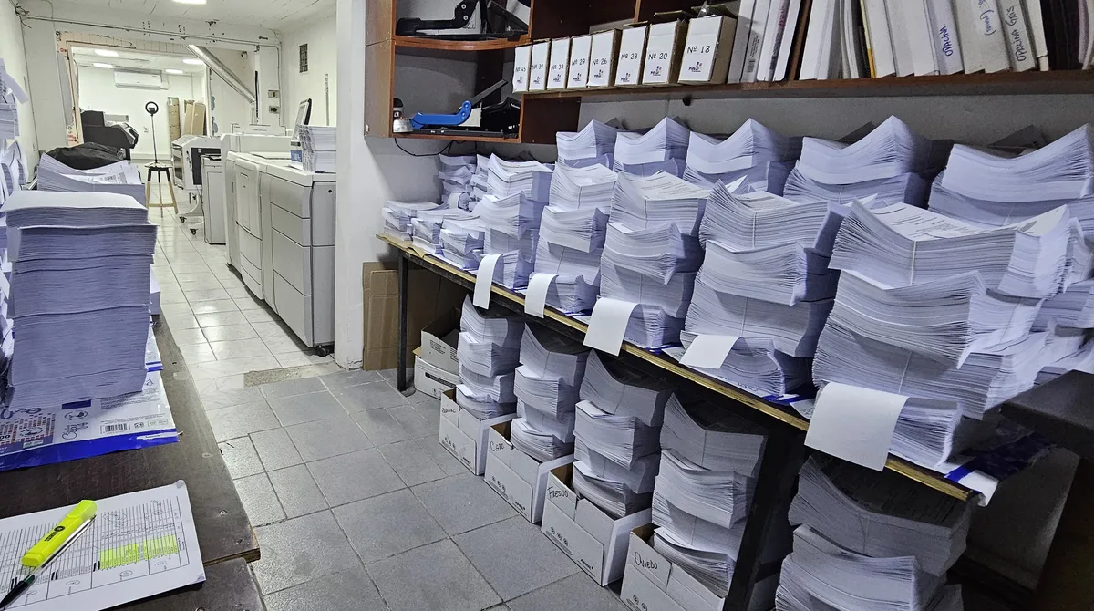 Estanterías de producción de EDOO con guías y pruebas escolares impresas, clasificadas y ordenadas por cajas listas para su distribución